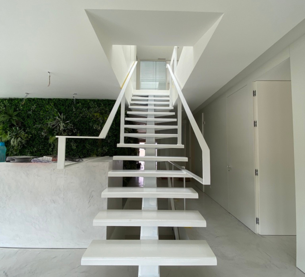 Escadaria suspensa em estrutura metálica branca com jardim vertical verde - sede Lacticoop, Contracta Engenharia